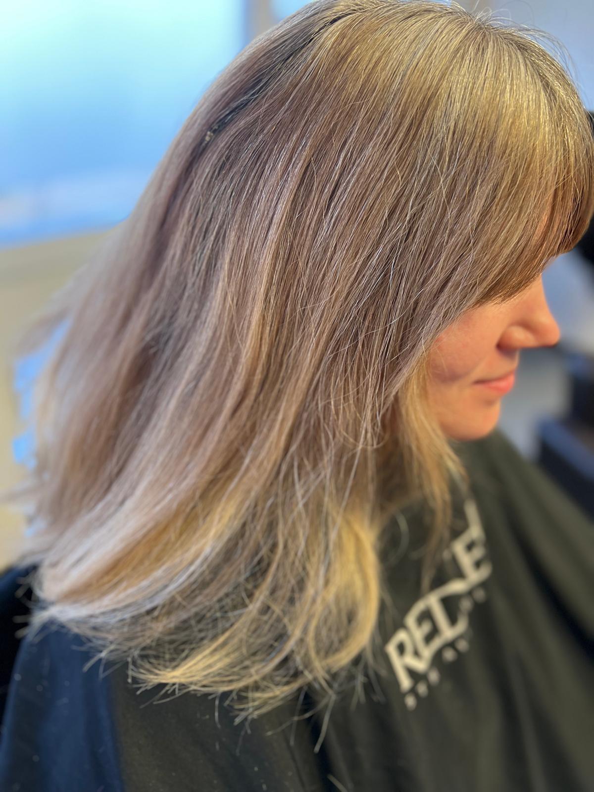 Vorher-Aufnahme mit warmem, mehrdimensionalem Blond und längerer Schnittlinie.